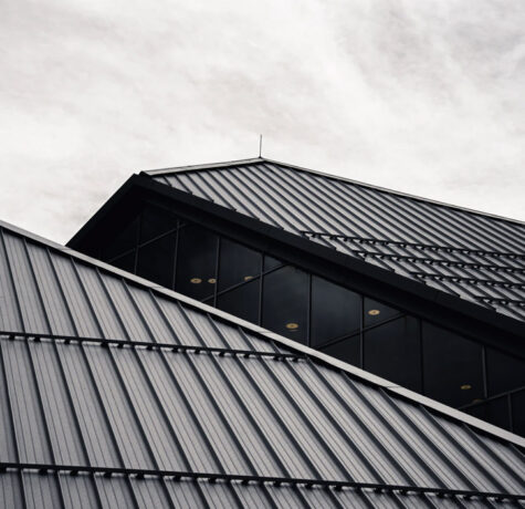 Modern building with sleek, angular rooflines under a cloudy sky.