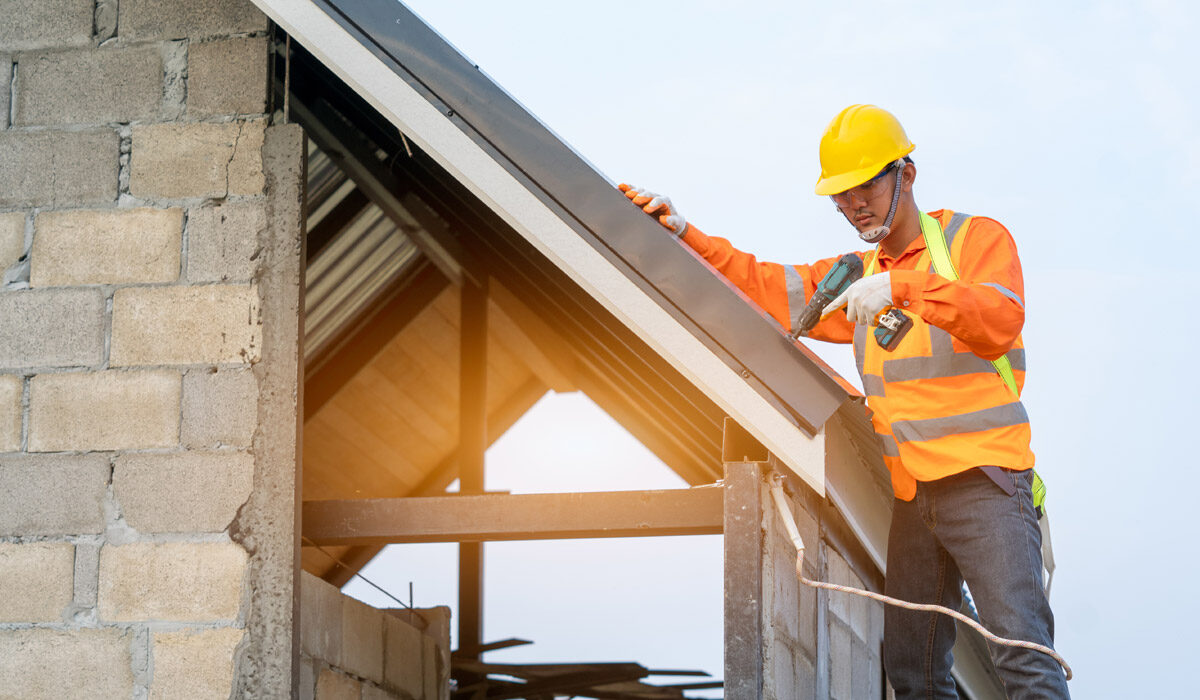 Construction worker installing solar panels on a rooftop.
