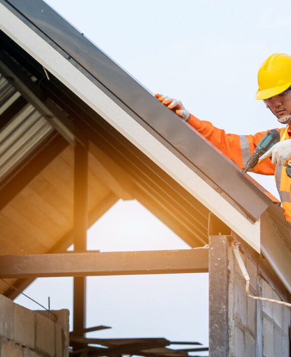 Construction worker installing solar panels on a rooftop.