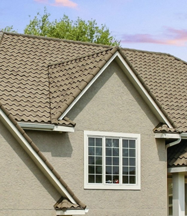 Close-up of a house roof with textured shingles and a window.