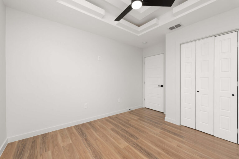 Empty room with hardwood floor and white walls.