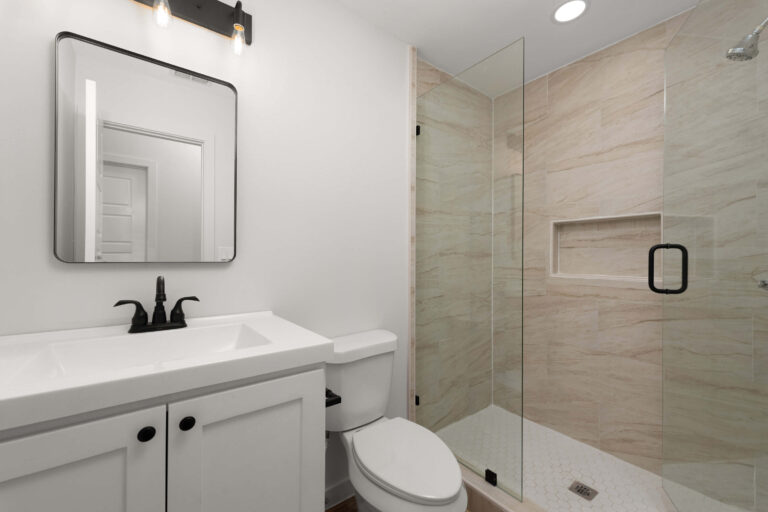 Modern bathroom with glass shower and white vanity.