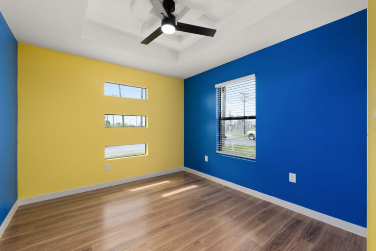 Bright room with yellow and blue walls and wooden flooring.