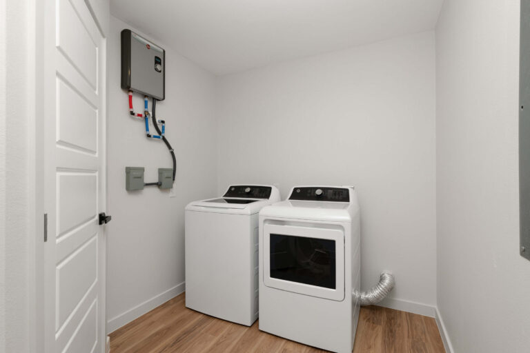A modern laundry room with a washer, dryer, and electrical panel.