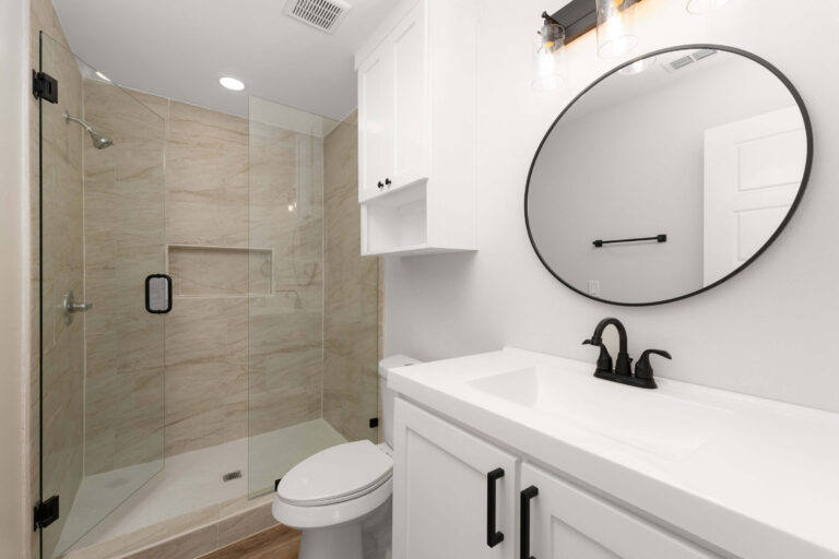 Modern bathroom with glass shower and white vanity.